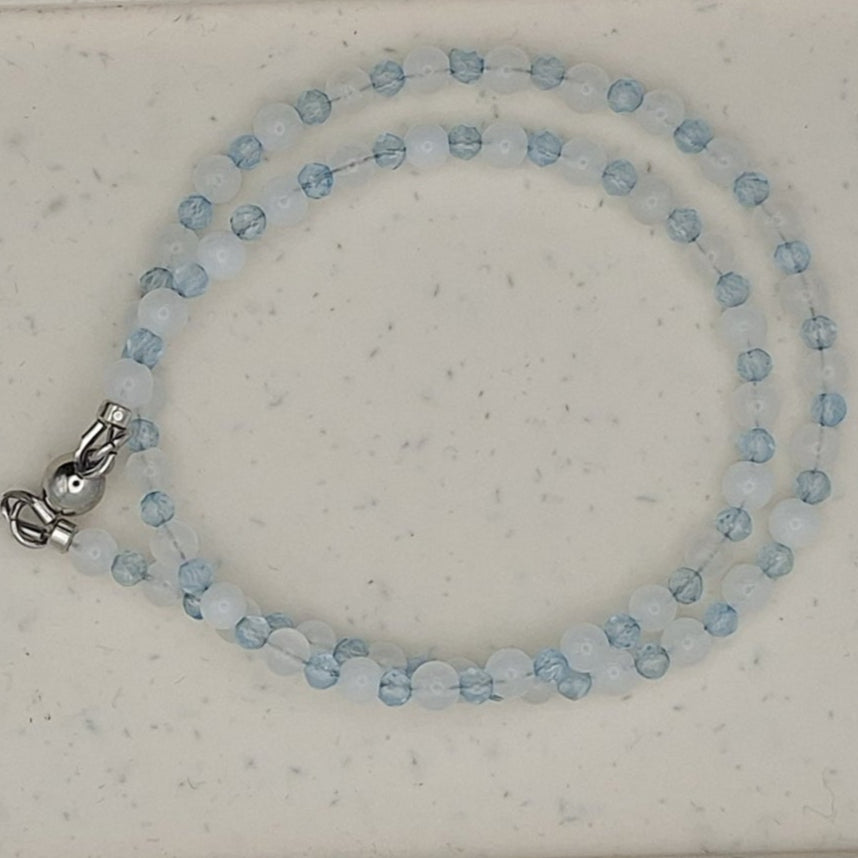 Beaded necklace on a white oval display card with a light gray background