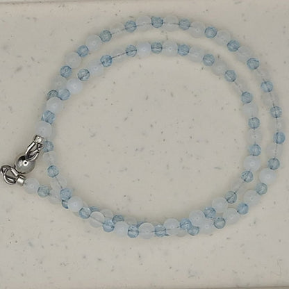 Beaded necklace on a white oval display card with a light gray background